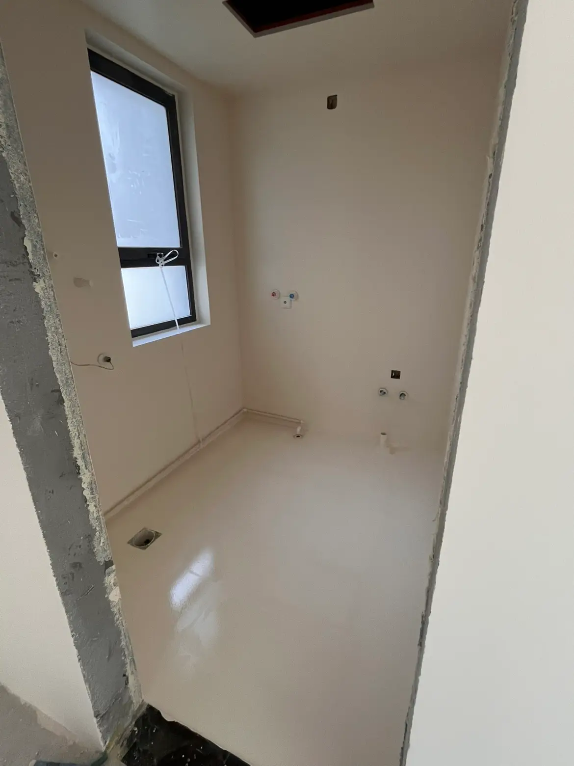 Completed light-colored floor in a residential utility area.